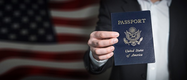 Man holding a U.S. USCIS passport in front of an American flag