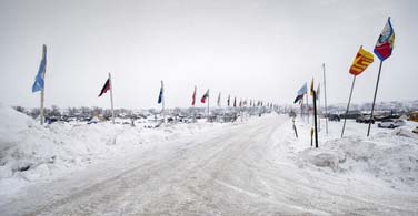 PIctured: A snowy road with flags in North Dakota.