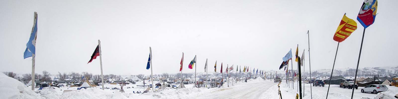 PIctured: A snowy road with flags in North Dakota.