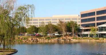 This is an image of commercial buildings across a lake in Plano. ASTA-USA provides translation services in this city.